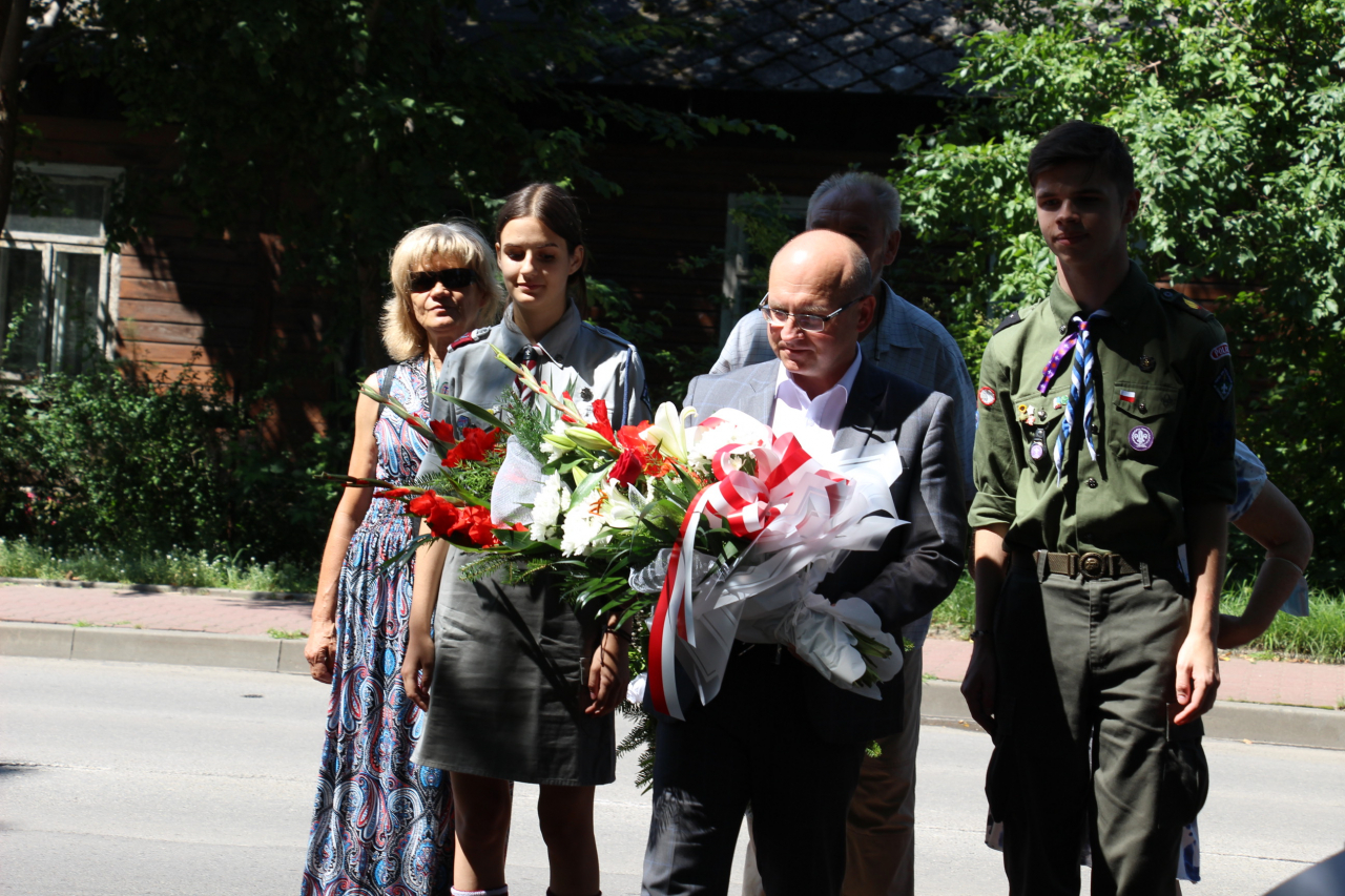 Burmistrz z harcerzami składa kwiaty pod pomnikiem